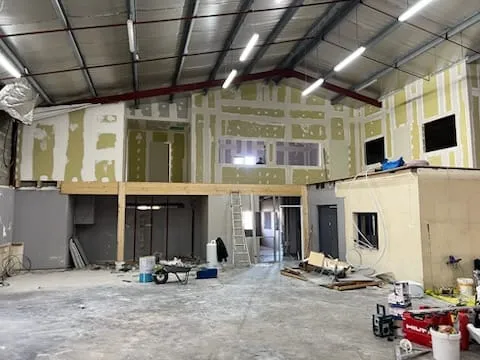 Hangar professionnel aménagé en bureaux avec cloisons en plaques de plâtre et mezzanine
