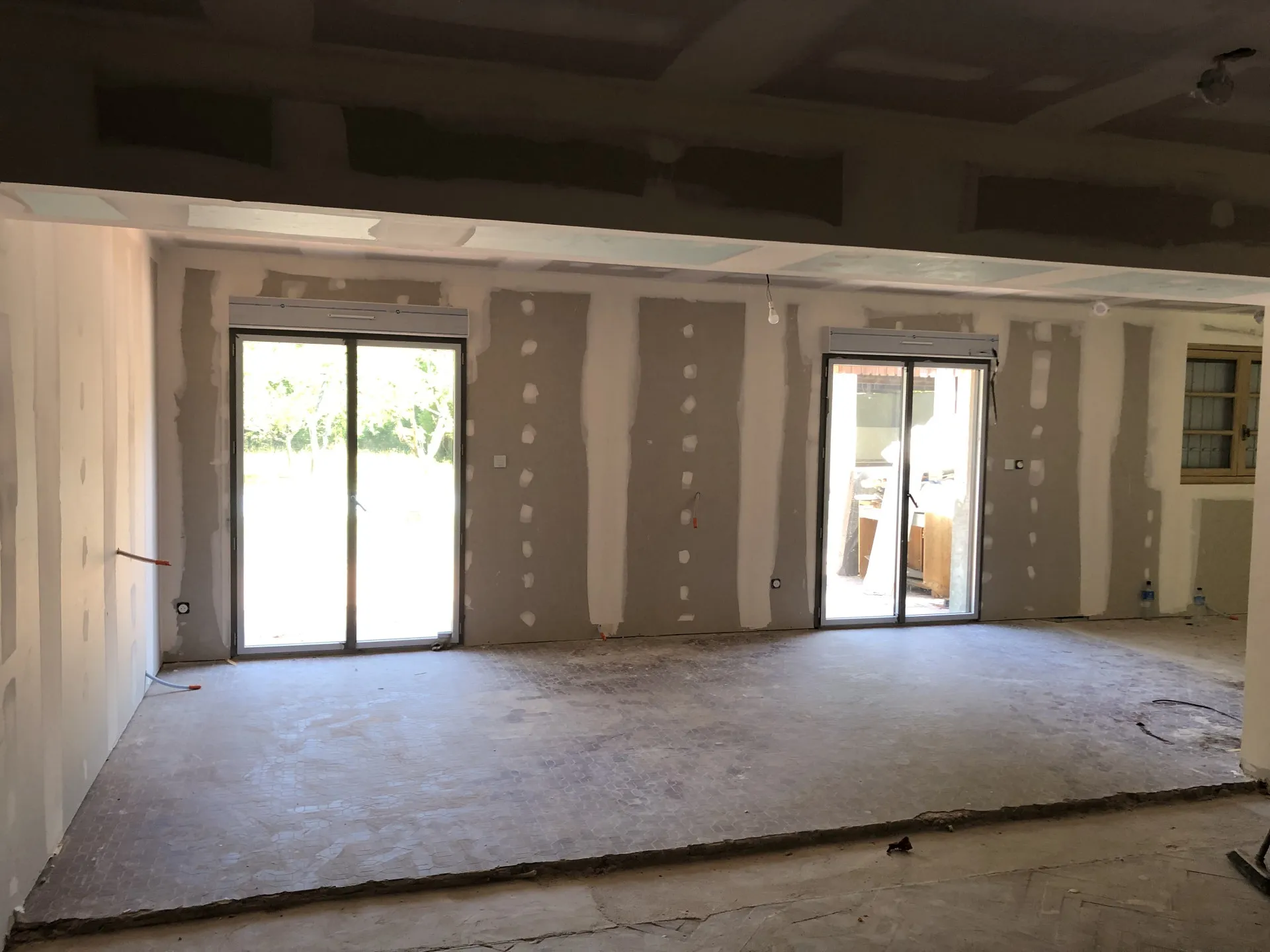 Cloisons et plafond en plaques de plâtre jointoyés dans une rénovation baignée de lumière